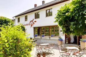 a restaurant with tables and chairs in front of a building at Gasthof & Landhotel Ohrnbachtal in Weilbach