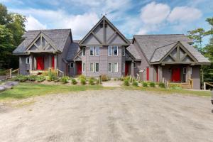 una casa gris con puertas rojas y entrada en Jay Peak Townhouse en Jay