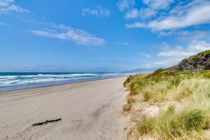 a sandy beach with the ocean in the background at 4th Avenue Beach Cottage in Rockaway Beach
