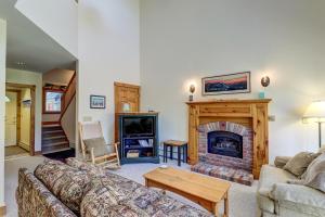 sala de estar con sofá y chimenea en Jay Peak Townhouse, en Jay