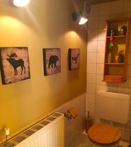 a bathroom with a toilet and pictures of animals on the wall at House Apricot in Krefeld