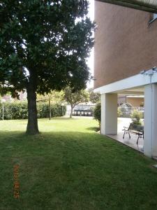 um parque com uma árvore e um banco ao lado de um edifício em Albergo Guido Reni em Turim