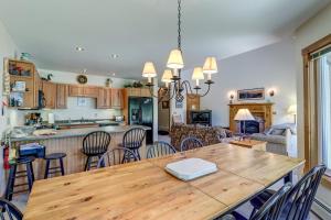 uma cozinha e sala de estar com uma mesa de madeira e cadeiras em Jay Peak Townhouse em Jay