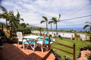 eine Terrasse mit Tisch und Stühlen und einem Pool in der Unterkunft Casa Victor in La Orotava