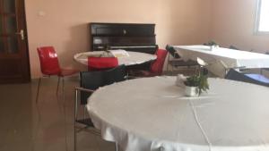 a room with two tables and chairs and a piano at Hotel Le Littoral Des Almadies in Dakar