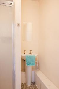 a white bathroom with a sink and a mirror at Dunes Hotel in Whitley Bay
