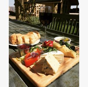 a wooden cutting board with food and a glass of wine at The Horseshoe & Castle in Rochester