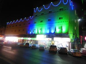 a building with cars parked in front of it at night at Holiday Furnished Units in Dammam