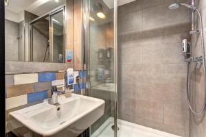 a bathroom with a sink and a shower at MEININGER Hotel Berlin Tiergarten in Berlin