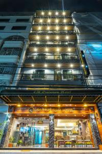 um edifício de apartamentos com um restaurante em frente em 4M Pratunam Hotel em Bangkok