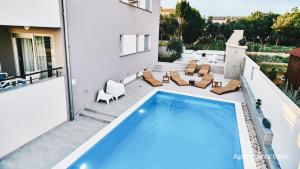 a swimming pool on the patio of a house at Salis Apartments in Vrsi