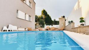 a swimming pool in the backyard of a house at Salis Apartments in Vrsi