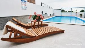 a pair of lounge chairs sitting next to a pool at Salis Apartments in Vrsi