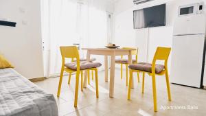a kitchen with a table and four chairs at Salis Apartments in Vrsi