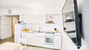 a white kitchen with a sink and a mirror at Salis Apartments in Vrsi