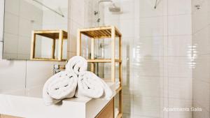 a bathroom with towels on a sink and a mirror at Salis Apartments in Vrsi