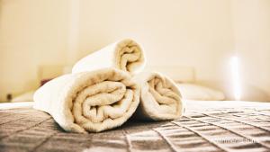 a pile of towels sitting on top of a bed at Salis Apartments in Vrsi