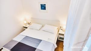 a small bedroom with a bed and two night stands at Salis Apartments in Vrsi +30 photos