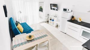 eine Küche und ein Wohnzimmer mit einem blauen Sofa und einem Tisch in der Unterkunft Salis Apartments in Vrsi