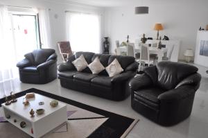 a living room with two leather couches and a table at Casa Manuela in Ericeira