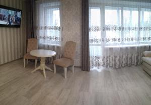 a living room with a table and chairs and a window at Apartment IriS in Baranavichy