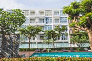 At Seacondo-1 Bedroom-A25 في كلونغ موانغ بيتش: مبنى شقق فيه مسبح واشجار