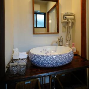 a bathroom with a large bowl sink on a wooden counter at Ryokoji Temple in Minami Aso