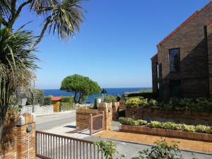 una casa con una valla de madera y un patio en Noja Playamar Apartment, en Noja