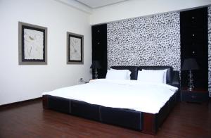 a bedroom with a large bed with a black headboard at Safari Club 1 in Rawalpindi