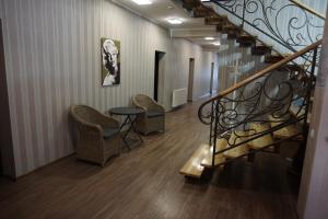 a staircase with chairs and a table in a building at Hotel Central Park in Velyikyy Bychkiv