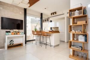 een keuken en een woonkamer met een bar en een televisie bij Kerem Charm by Five Stay in Tel Aviv