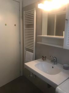 een witte badkamer met een wastafel en een spiegel bij Casa Valparaiso in Chiavari