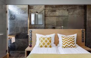een slaapkamer met een bed met gele en witte kussens bij Kamieniec 27 Bed & Breakfast in Zakopane
