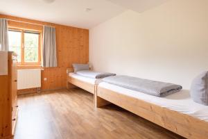 a bedroom with two beds and a window at Haflingerhof - Kematsried in Bad Hindelang