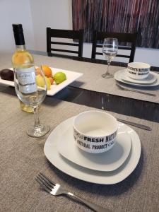 a table with plates and glasses and a bottle of wine at Departamento en San Juan, Argentina in San Juan