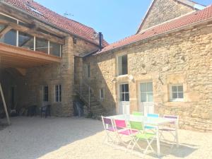 un tavolo e sedie di fronte a un edificio in pietra di Relais de la truffière a Villaines-en-Duesmois