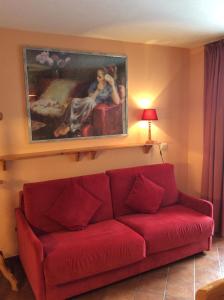 um sofá vermelho numa sala de estar com um quadro na parede em Residenze Sonnenschein Casa Rossa em Villabassa