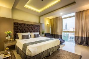 a hotel room with a bed and a large window at Al Muhaidb Al Takhasosi Suites in Riyadh