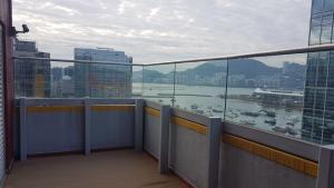 een balkon van een gebouw met uitzicht op een haven bij IW Hotel in Hong Kong