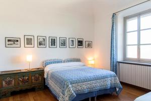 sypialnia z łóżkiem, 2 lampami i oknem w obiekcie Villa Fiorita w mieście Castello di Annone