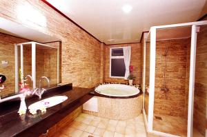 a bathroom with a tub and a sink and a shower at 意大利商務溫泉汽車旅館 in Jiaoxi