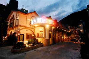 a building with a neon sign on it at night at 意大利商務溫泉汽車旅館 in Jiaoxi