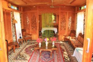 a living room with a table with flowers on it at Umbrella group of House Boat in Srinagar