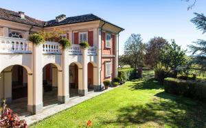 una casa grande con un patio con césped verde en Villa Fiorita, en Castello di Annone