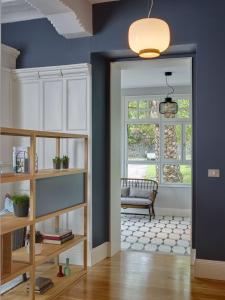 a living room with a blue wall and a window at Etxelaia in Gautegiz Arteaga