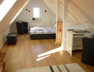 a bedroom with a bed and a desk in a attic at Ferienhaus Kozian in Kühlungsborn