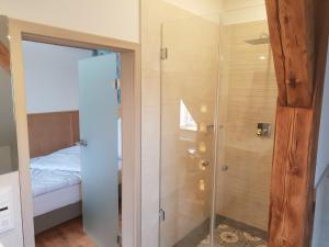 a glass shower in a bedroom with a bed at Hotel 1782 - Contactless self check-in in Remscheid