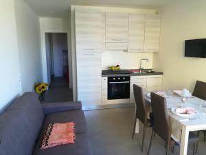 a living room with a blue couch and a kitchen at Tulipano Appartamenti in Marotta