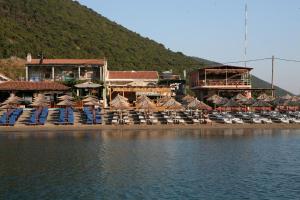 a beach with chairs and umbrellas next to the water at Apartments Boss in Budva
