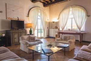 salon z dwoma krzesłami i stolikiem kawowym w obiekcie Villa Fiorita w mieście Castello di Annone